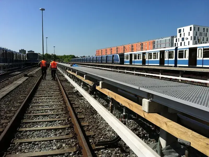 Pultruded FRP rail platform walkway along transit tracks with a non-conductive surface