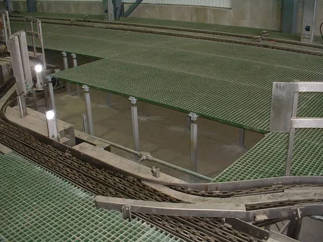 Large green FRP grating platform beside conveyor lines in a food processing facility