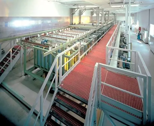 FRP grating walkway and access platform running alongside automated production equipment inside a pharmaceutical plant